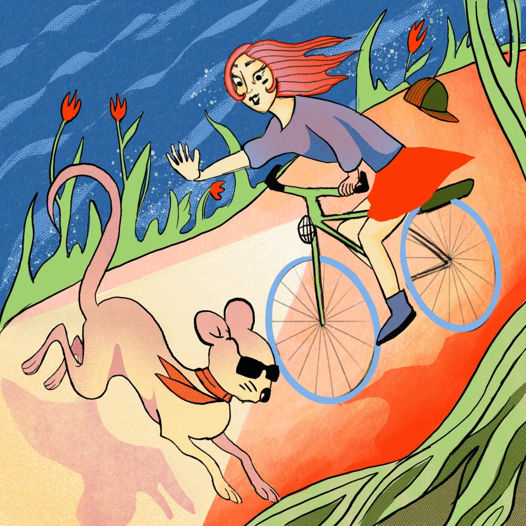 A red-haired woman cycles downhill waving, while a dog in sunglasses and a red neckerchief runs beside her past red tulips.